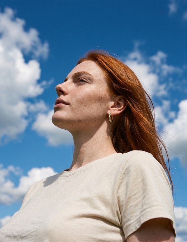 Red-haired model wearing gold earrings