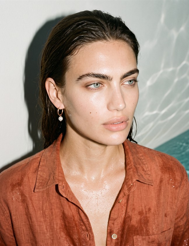 Model wearing drop earrings