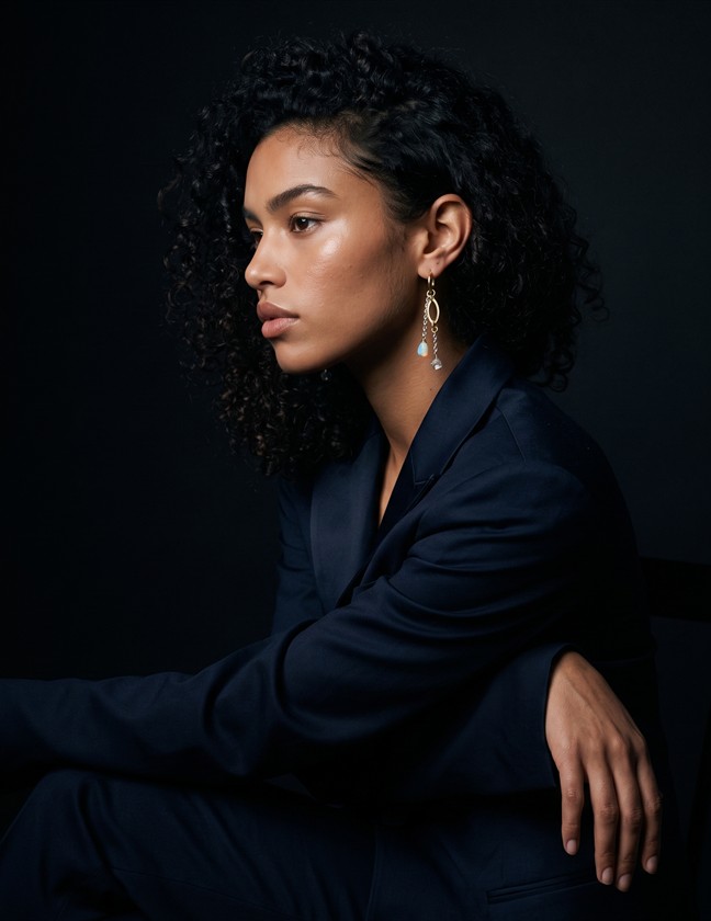 Editorial model wearing gold drop earrings
